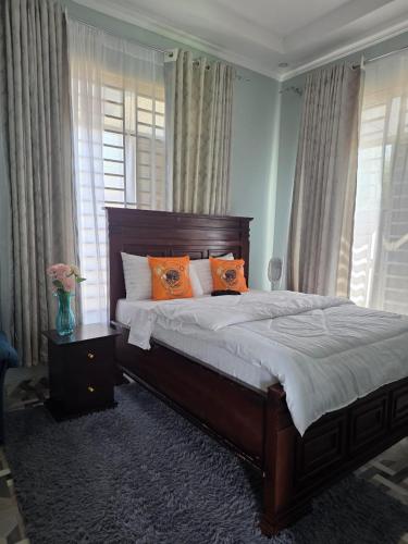 a bedroom with a large bed with orange pillows at VC Heritage Residences in Dodoma
