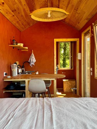a bedroom with a table and a sink in a room at Tiny House en lisière de bois in Bastennes