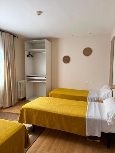a hotel room with two beds with yellow sheets at Hotel 139 in Castelldefels