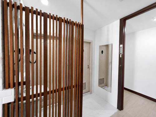 a hallway with a wooden pivot door and a mirror at The 789 House in Chiang Mai