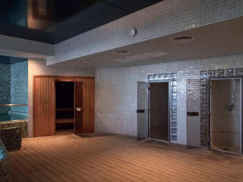 a room with two doors and a tile wall at Ona Marinas de Nerja Spa Resort in Nerja
