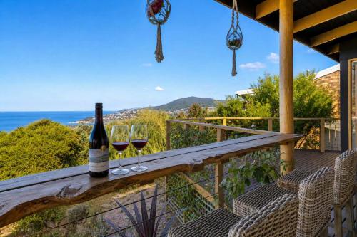 a table with two glasses of wine on a balcony at Ocean Views 20kms from CBD Sleeps 10 in Kingston Beach