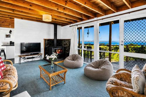 a living room with couches and a tv and a fireplace at Ocean Views 20kms from CBD Sleeps 10 in Kingston Beach