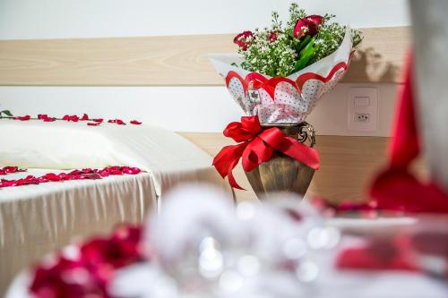 a vase filled with flowers sitting next to a table at Laguna Praia Hotel in João Pessoa