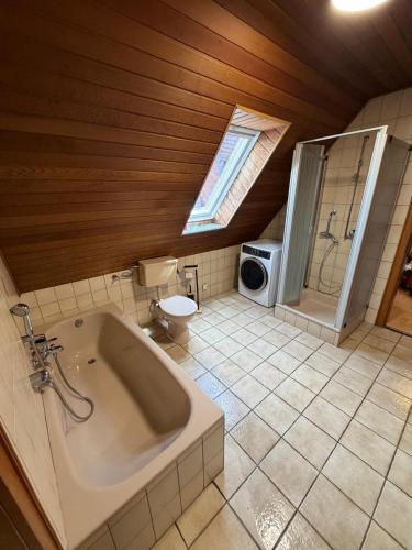 a bathroom with a tub and a toilet and a shower at Monterus Fürst in Fürstenau