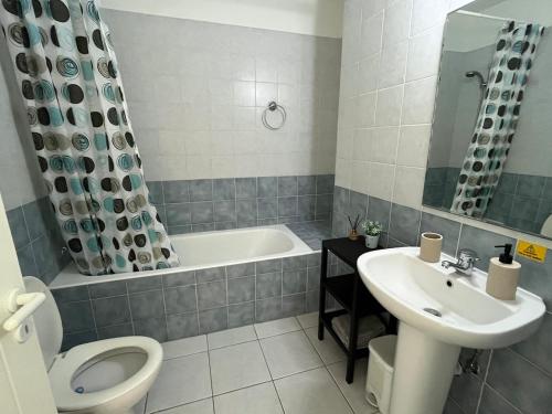 a bathroom with a tub and a sink and a toilet at Pegeia Sun in Peyia