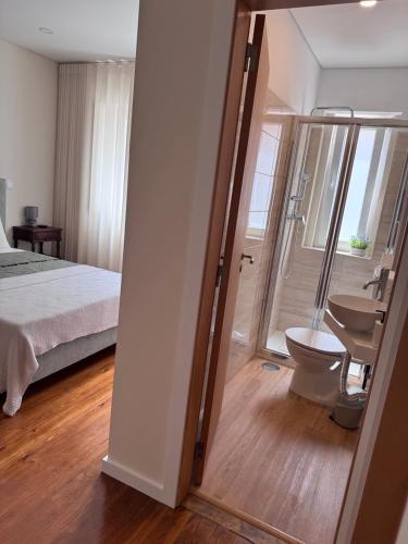 a bedroom with a bed and a bathroom with a toilet at Luna Navegante in Porto