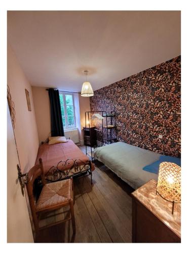 a bedroom with two beds and a wall covered in wallpaper at Logis du mont in Saint-Sernin-du-Plain