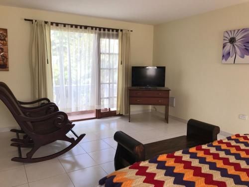 a bedroom with a tv and a chair and a bed at La Quinta San Andrés in Ibarra