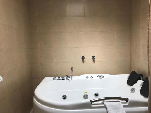 a bathroom with a white tub and a toilet at La Quinta San Andrés in Ibarra