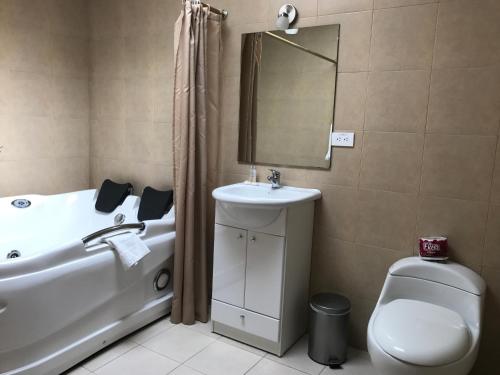 a bathroom with a tub and a sink and a toilet at La Quinta San Andrés in Ibarra