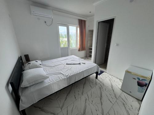 a white bedroom with a bed and a window at Chocolate in Ureki