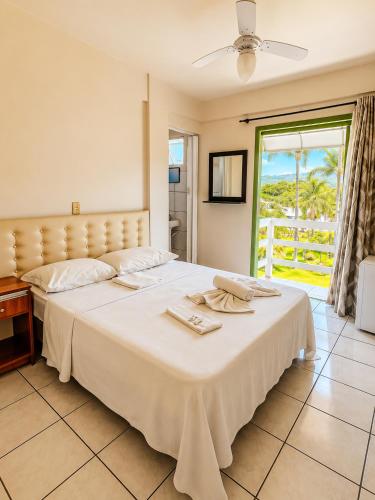 a bedroom with a large bed with towels on it at Hotel Centro dos Canyons in Praia Grande