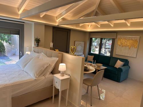 a bedroom with a bed and a couch and a table at Sunset Suite Mytikas in Mytikas