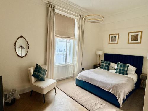 a bedroom with a bed and a chair and a window at 'Gordon' in ApartNest Auchterarder in Auchterarder