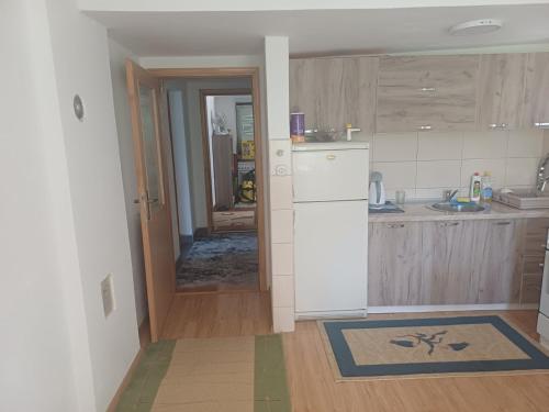 a kitchen with a sink and a refrigerator in it at Apartman BelSa in Sarajevo