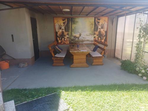a patio with a table and some animals on the wall at Apartman BelSa in Sarajevo