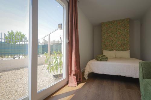 a bedroom with a bed and a large window at La Casa Contenedor Loft in Zaragoza