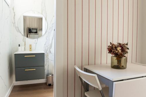 a bathroom with a table with a vase of flowers at La Casa Contenedor Loft in Zaragoza
