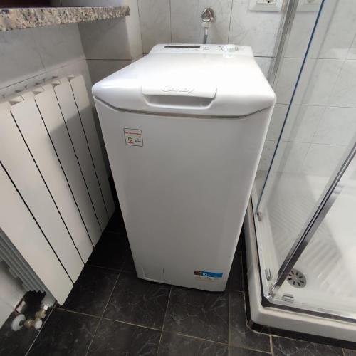 a small white refrigerator in a bathroom next to a shower at Casa Iris in Somma Lombardo