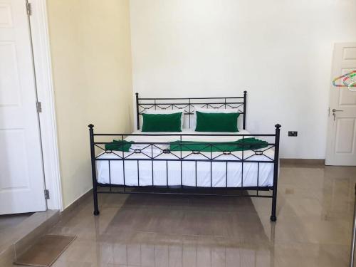 a bed with green pillows on it in a room at Dee Holidays in Moratuwa