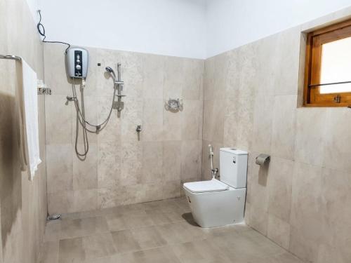 a bathroom with a shower and a white toilet at Dee Holidays in Moratuwa