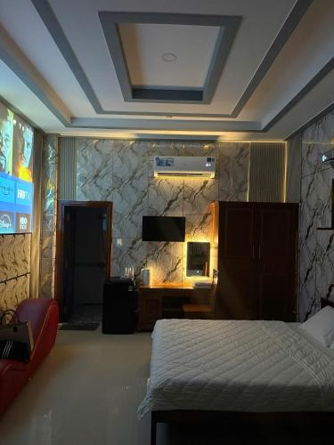 a bedroom with a bed and a desk and a tv at Motel Long Thành Quang in Long Thành