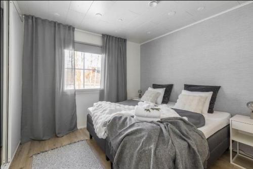 a bedroom with a large bed and a window at Joulupukin talolla in Rovaniemi