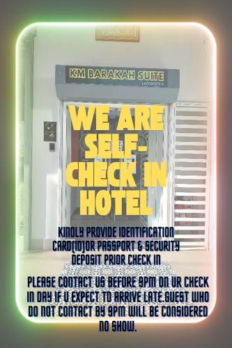 a sign that says we are self check in hotel at KM Barakah Suite Kuala Terengganu in Kuala Terengganu