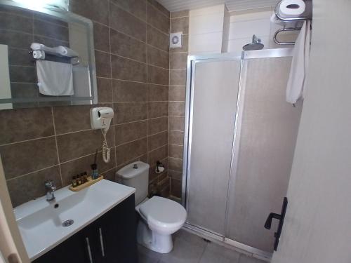 a bathroom with a shower and a toilet and a sink at Zone Guest House Bellapais in Kyrenia