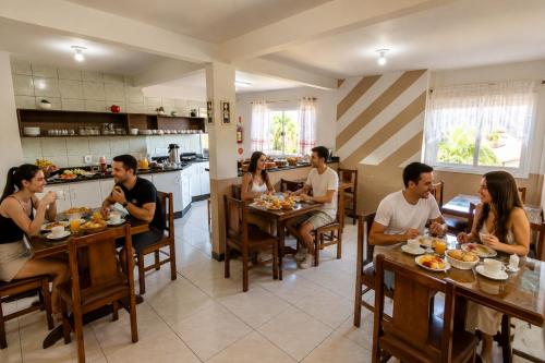 a group of people sitting at tables in a restaurant at Hotel Centro dos Canyons in Praia Grande