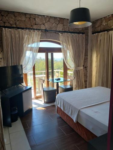a bedroom with a bed and a table and a balcony at Zone Guest House Bellapais in Kyrenia