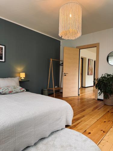 a bedroom with a bed and a chandelier at The Forest room in Ikšķile