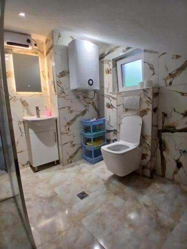 a bathroom with a toilet and a sink at Apartman Nature in Konjic