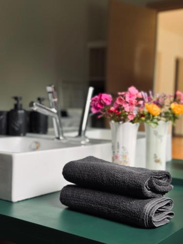 a pile of towels sitting on a counter next to a sink at The Forest room in Ikšķile