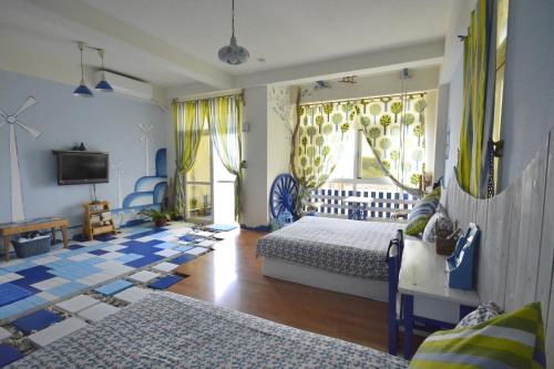 a bedroom with two beds and a television in it at Happiness Factory in Huxi