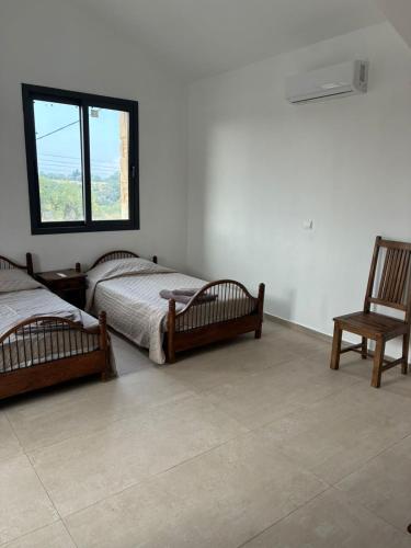 two beds in a room with a chair and a window at LasaThea in Lasa