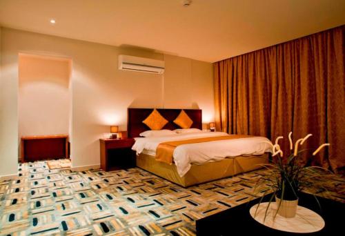 a hotel room with a bed and a table at شقق الآجنحة التنفيذية للشقق المخدومة in Riyadh