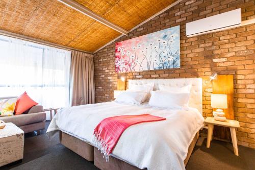 sypialnia z dużym łóżkiem i ceglaną ścianą w obiekcie Farnham Court Motel and Restaurant w mieście Morwell