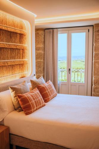 a bedroom with a large bed with a window at La Venta de Bodegas Ostatu in Samaniego