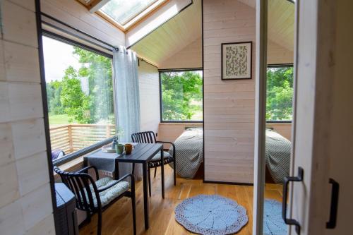 a tiny house with a porch with a table and chairs at Suur Muna Apple Garden Tiny Houses in Haanja