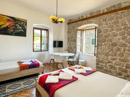 a room with two beds and a table in it at LaRos Apt in Herceg-Novi