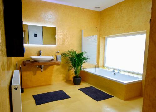 a bathroom with a tub and a sink at Odavagyok Vendégház in DiÃ³sviszlÃ³