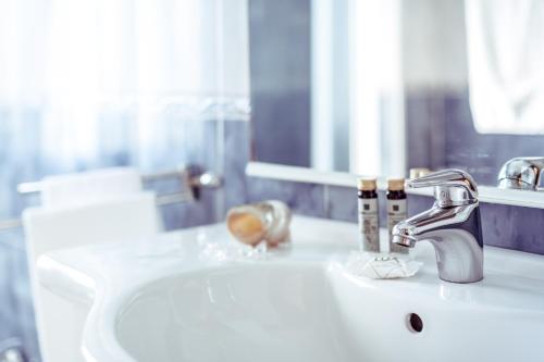 a bathroom sink with a faucet and a mirror at Le Terrazze in Follonica