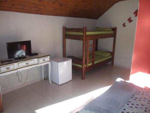 a room with two bunk beds and a television at Rancho Pôr Do Sol in Arapeí