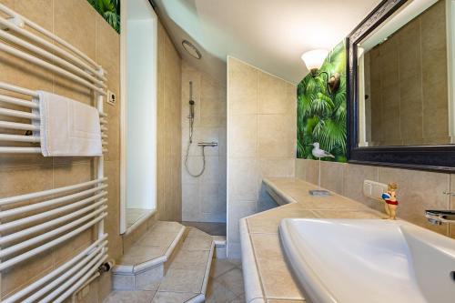 a bathroom with a tub and a shower and a sink at Meermaler in Ahrenshoop