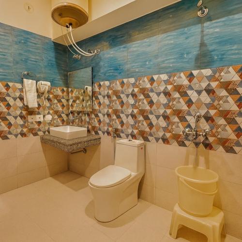 a bathroom with a toilet and a sink at The kempty Fall Resort, Mussoorie - Lavish & Luxury Stay in Mussoorie