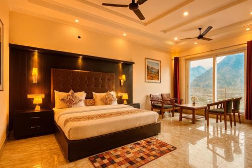 a bedroom with a large bed and a large window at The kempty Fall Resort, Mussoorie - Lavish & Luxury Stay in Mussoorie