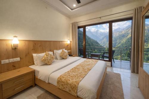 a bedroom with a bed with a view of mountains at The Spring Dale Resort, Mussoorie by Sitara group - Best Selling Resort in Mussoorie 2025-26 in Mussoorie