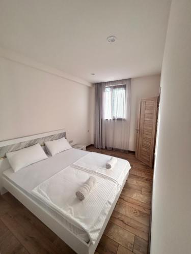 a white bed in a room with a window at Your Cozy Home 2BR Local Vibe 25 Mins to Center in Yerevan